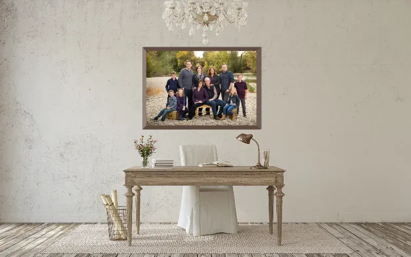 A long framed family portrait on an exposed brick wall above a bench