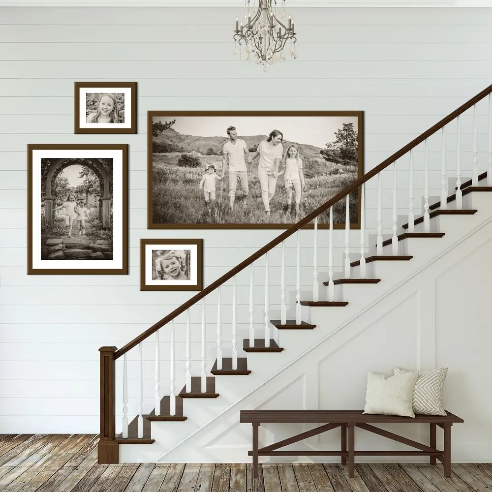 A staircase gallery wall of framed family portraits